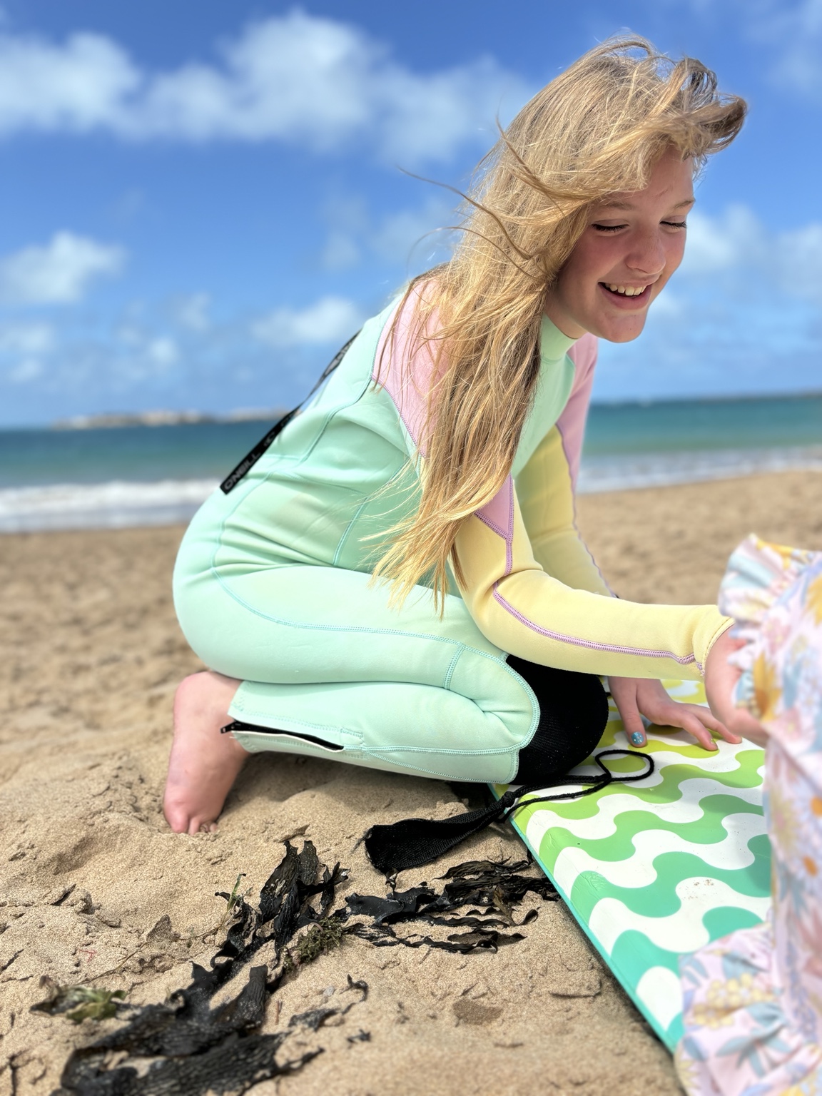 Aubrie smiling on a bright beach