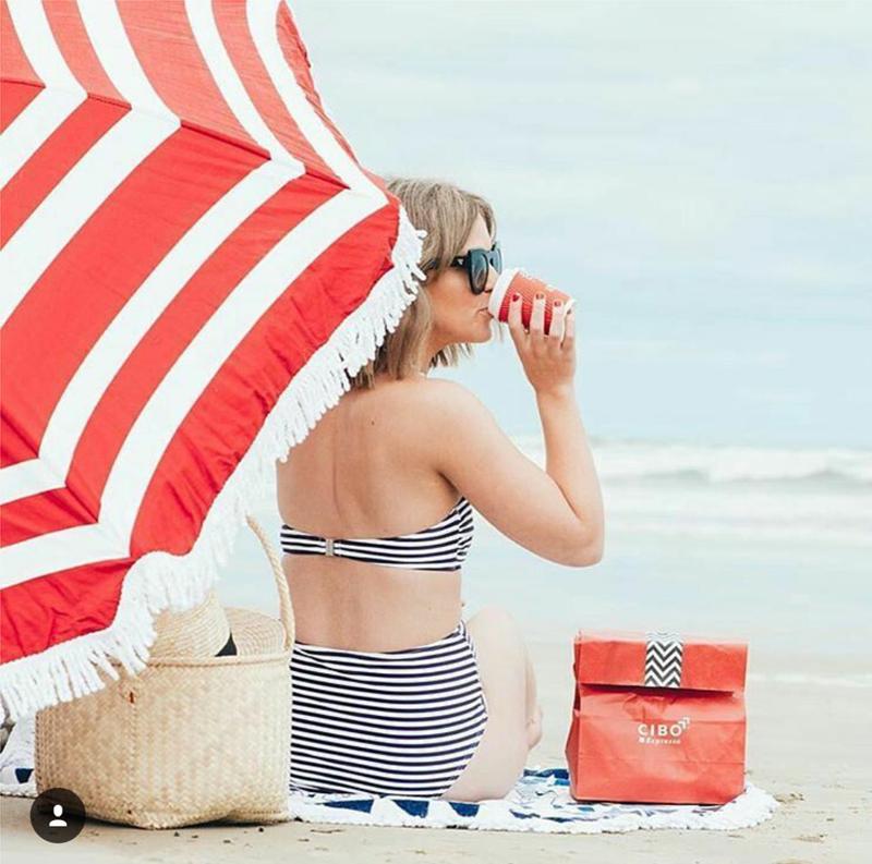 Jaz holding a CIBO Espresso cup during a beach campaign